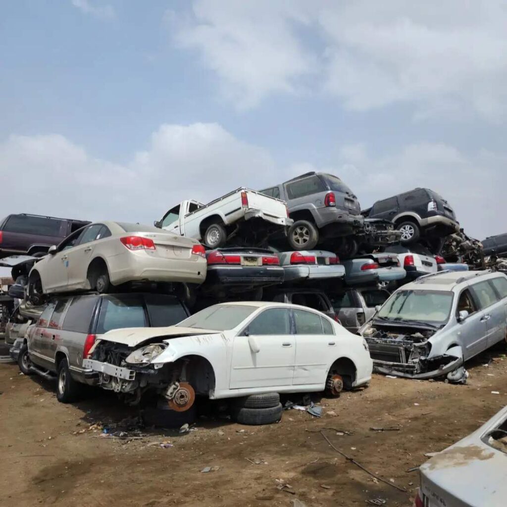 Many scrapped cars stacked in a scrapyard representing car dismantling and used parts availability in Buraidah