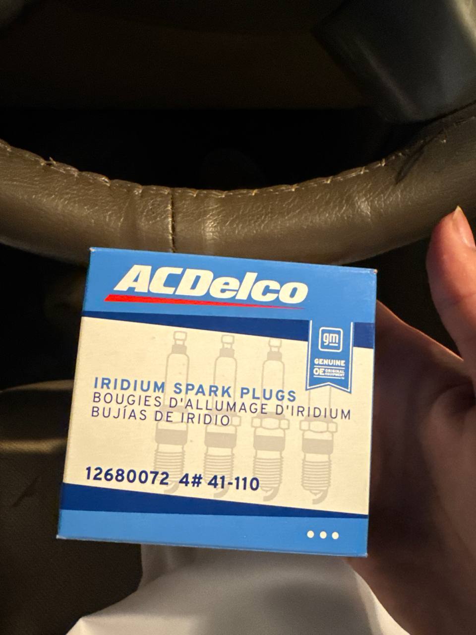 يد تمسك علبة بواجي ACDelco أصلية رقم 41-110 أمام دركسون تاهو